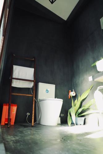 a bathroom with a toilet and a plant at The Jini House in Ahangama