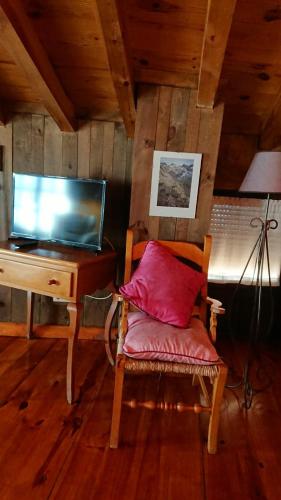 a chair with a red pillow sitting next to a desk at Artesano I y III in Navarredonda de Gredos