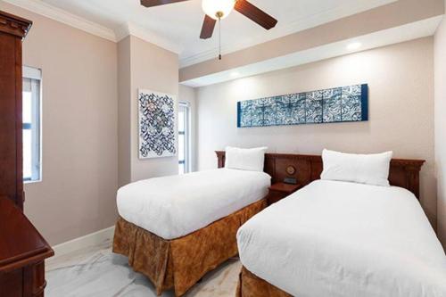 a bedroom with two beds and a ceiling fan at WESTGATE PALACE RESORT in Orlando