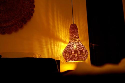 a wicker lamp hanging from a wall at The Jini House in Ahangama