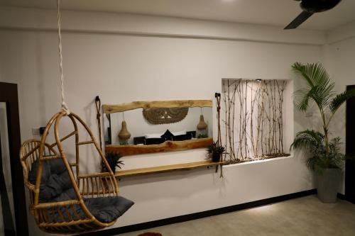 a room with a hanging chair and a window at The Jini House in Ahangama