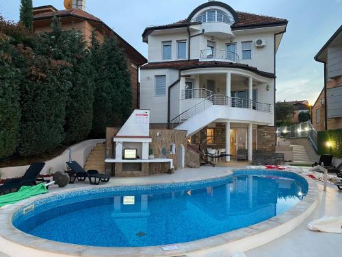 una casa con piscina frente a una casa en Freya SPA Apartments, en Niš