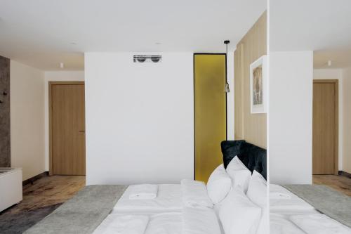 a bedroom with a white bed and a couch at Boutique Macchiato Rooms in Novi Sad