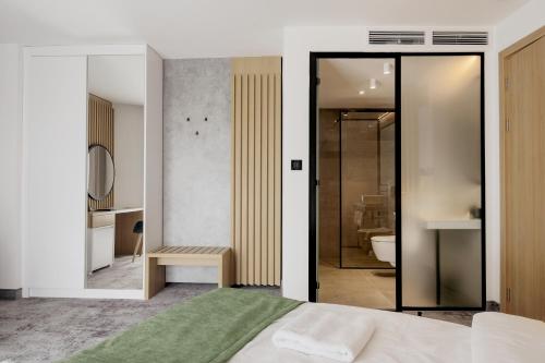 a bedroom with a bed and a bathroom at WellNS Rooms in Novi Sad