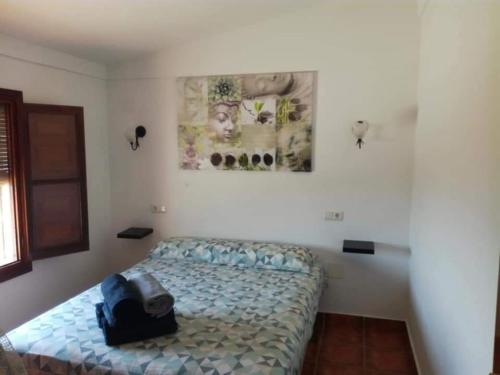 ein Schlafzimmer mit einem Bett und einem Rucksack darauf in der Unterkunft Casa Rural El Mirador in Vélez-Málaga