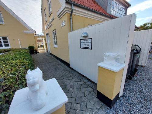 a couple of white statues sitting next to a building at Toftegården Guesthouse - Rooms in Skagen