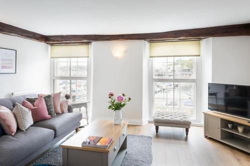 a living room with a couch and a tv at Blue Skies Apartment - Marina Views in Torquay