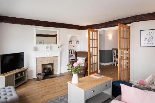 a living room with a couch and a fireplace at Blue Skies Apartment - Marina Views in Torquay