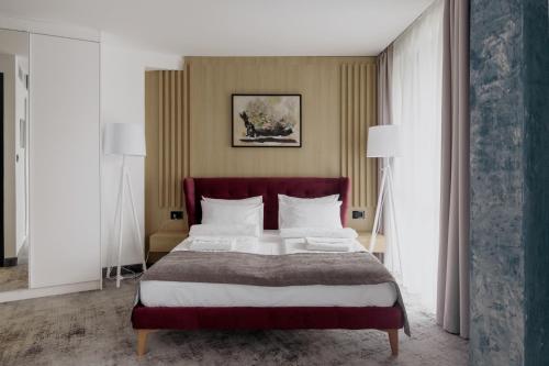 a bedroom with a large bed and two lamps at WellNS Rooms in Novi Sad