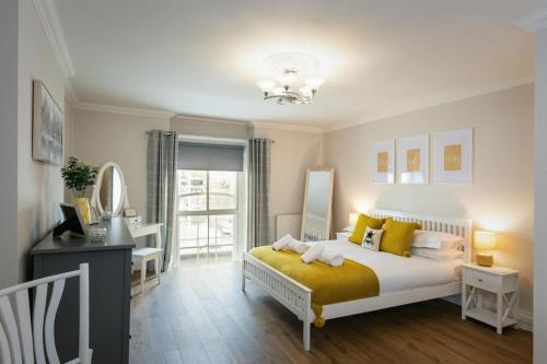 a bedroom with a bed with a yellow blanket at Blue Skies Apartment - Harbour Views in Torquay