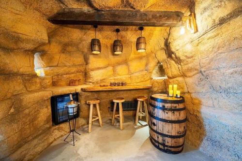 a room with a barrel and a table and stools at Clwyd Gate Manor Pool Sauna HotTub Cave Wales in Ruthin