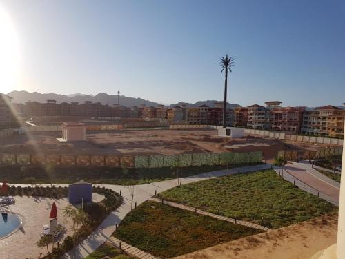 a view of a resort with a pool and a palm tree at Duplex apartment in Porto Sharm El skeikh in Sharm El Sheikh