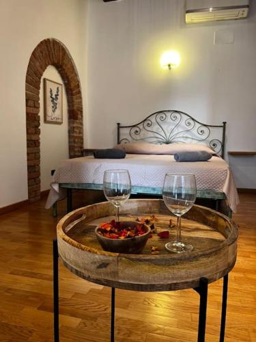 una camera con un letto e un tavolo con due bicchieri da vino di Il Grappolo d’Alba ad Alba