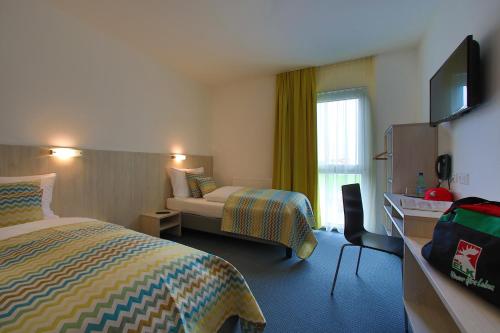 a hotel room with a bedroom with a bed and a television at Best sleep Hotel in Spielberg