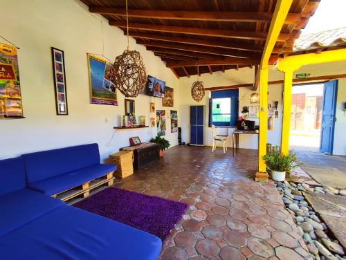sala de estar con sofá azul y mesa en Hostel Trip Monkey Barichara en Barichara