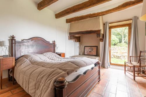 1 dormitorio con 1 cama grande, escritorio y ventana en Kerguestenen, en Inguiniel
