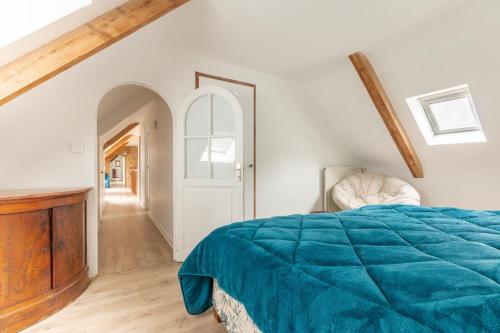 a bedroom with a bed with a blue blanket at Kerguestenen in Inguiniel
