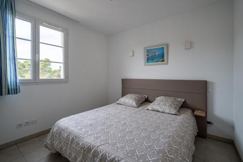 um quarto com uma cama e duas almofadas em Le Balina em Cabriès