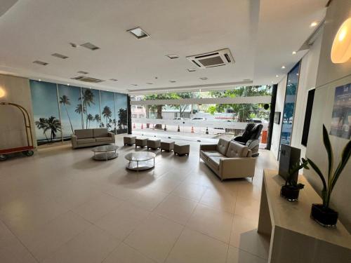 a large living room with couches and a tv in it at Navegantes apartamento in Recife