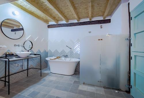 y baño con bañera, lavabo y espejo. en VEN LUNA, VEN Casa-SPA Astroturismo rural TR-CC-00361 en Casas del Castañar