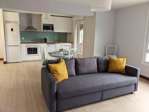 a living room with a blue couch and a kitchen at Apartamento Sanfuentes Bat in Sanfuentes