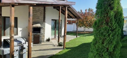 a house with a greenhouse and a tree next to it at Villa Gardenia in Sapareva Banya
