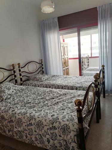 a bedroom with two beds and a window at Leonel Barcelos in Quarteira