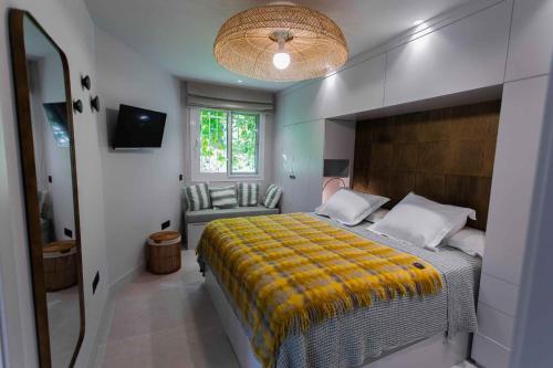 um quarto com uma cama grande e um cobertor amarelo em BungaLove em Benalmádena