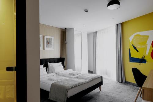 a bedroom with a bed and a yellow wall at Boutique Macchiato Rooms in Novi Sad