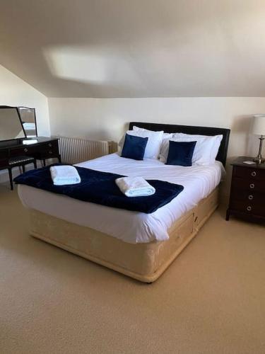 - une chambre avec un grand lit et des oreillers bleus dans l'établissement The Cottage, Hill Top Stables, à Esh