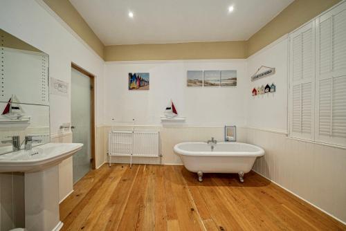 a bathroom with two sinks and a bath tub at Serviced Apartments Macclesfield in Macclesfield