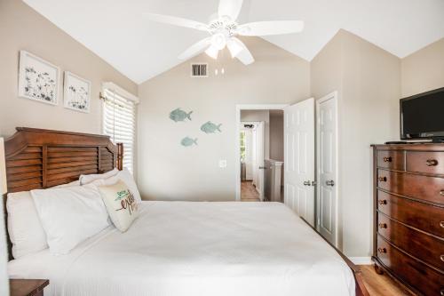 une chambre avec un lit et un ventilateur de plafond dans l'établissement Palm Breeze, à Duck Key