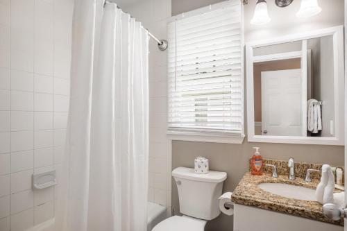 une salle de bain avec toilettes, lavabo et miroir dans l'établissement Palm Breeze, à Duck Key