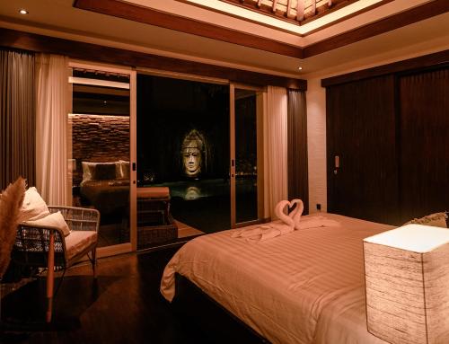 a bedroom with a bed with a pink swan on it at Sunset Palms Beach Villa in Jimbaran