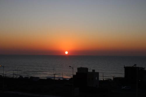 a sunset over the ocean with the sun in the sky at Amadel Surf & beach4 in Imsouane