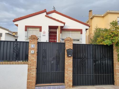 a fence with black gates in front of a house at Casa Rural Xauen in Belicena