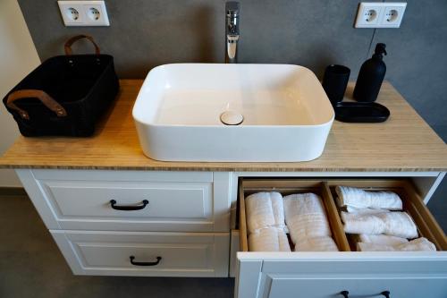 a bathroom vanity with a white sink and towels at Luxuriöse Maisonette Wohnung im Szenenviertel in Wuppertal