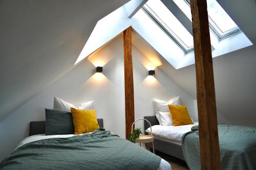 a attic bedroom with two beds and a skylight at Luxuriöse Maisonette Wohnung im Szenenviertel in Wuppertal