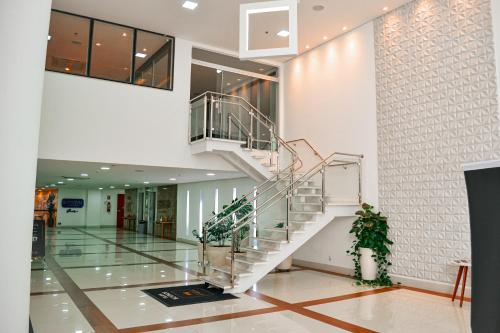 a spiral staircase in a building with a lobby at Nobile Inn London Anápolis in Anápolis