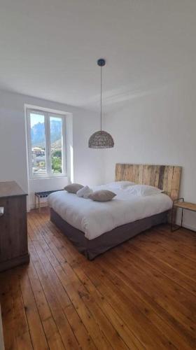 une chambre avec un grand lit et un parquet dans l'établissement The Cosy Penthouse Corté by 1722, à Corte