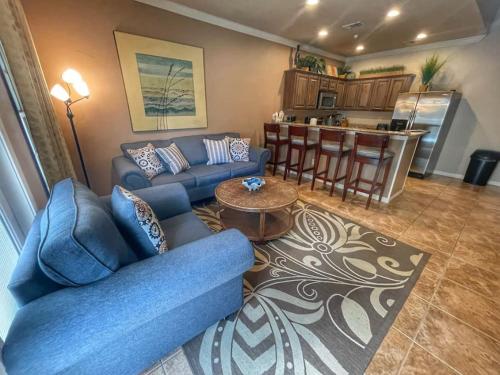 a living room with a blue couch and a kitchen at Long Weekend in New Braunfels