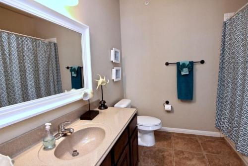a bathroom with a sink and a toilet and a mirror at Long Weekend in New Braunfels