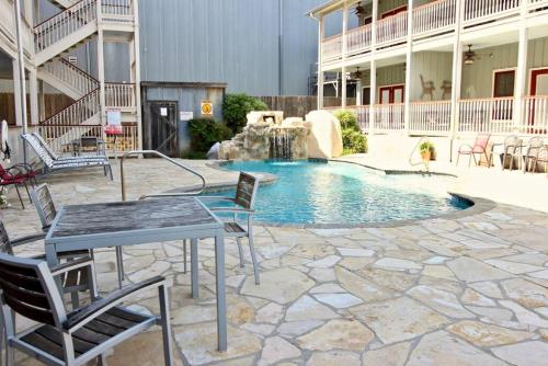 a patio with a table and chairs and a swimming pool at Long Weekend in New Braunfels