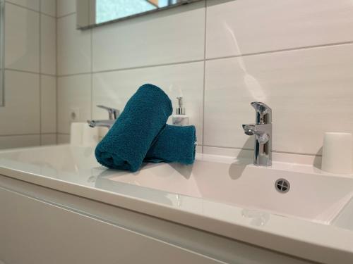 La salle de bains est pourvue d'une serviette bleue assise sur un lavabo. dans l'établissement Haus Blickfang, à Neustift im Stubaital