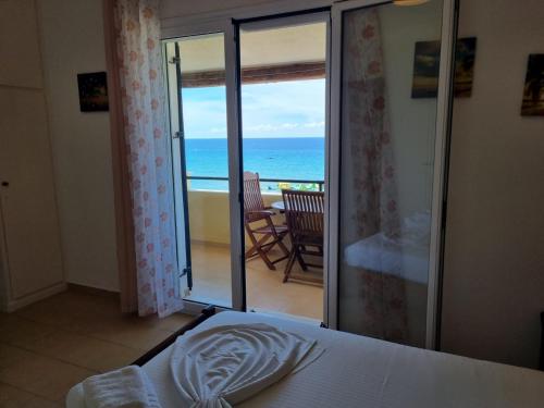 um quarto com uma cama e vista para o oceano em Corfu Glyfada Beach Apartment 59 em Glyfada