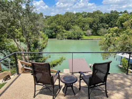 a patio with two chairs and a table and a lake at Lakeside Escape in McQueeney