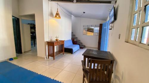a living room with a blue chair and a table at Aurora Hostel in Pipa