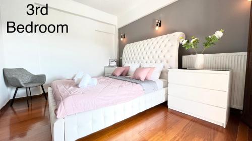 a bedroom with a white bed with pink pillows at GKK House private swimming pool luxury house in Skriperón