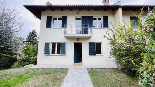 a white house with blue shutters and a balcony at Casa da Bertu in Barbaresco