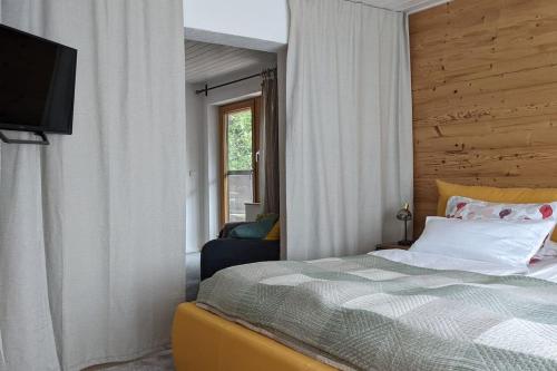een slaapkamer met een bed en een televisie. bij Ferienwohnung in ruhiger Lage direkt am Wald in Heidenheim an der Brenz